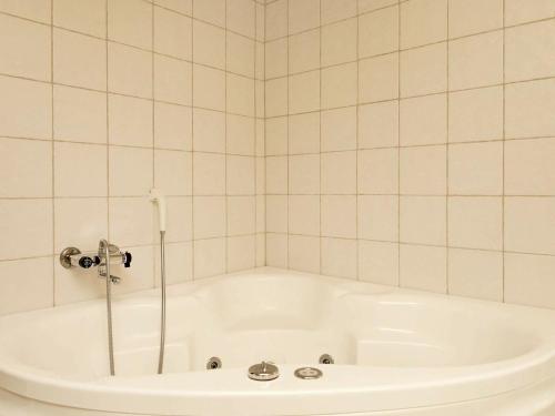 uma banheira com chuveiro numa casa de banho em azulejo em 10 person holiday home in lb k em Ålbæk