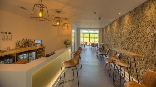 a bar with chairs and a counter in a restaurant at Denbies Vineyard Hotel in Dorking