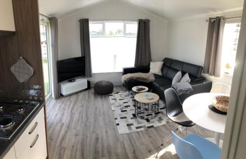 een woonkamer met een bank en een tafel bij Camping de Zandput - 604 in Vrouwenpolder