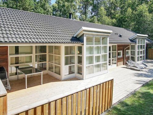 Cette grande maison dispose d'une terrasse en bois avec une table. dans l'établissement 10 person holiday home in Hasle, à Hasle
