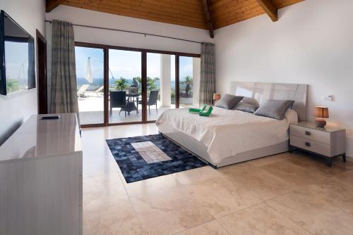 a bedroom with a bed and a view of a patio at Villa Dolphin Saint Martin in Orient Bay