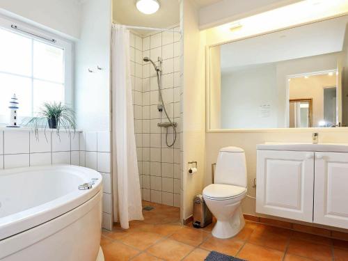 a bathroom with a tub and a toilet and a sink at 6 person holiday home in Vejby in Vejby