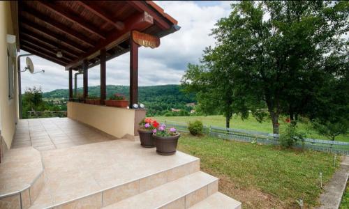 eine Veranda mit zwei Topfpflanzen auf einem Haus in der Unterkunft Apartment Josipa in Selište Drežničko