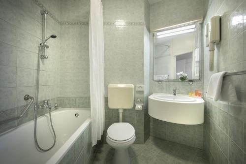 e bagno con servizi igienici, lavandino e vasca. di Rubin Hotel a Poreč (Parenzo)
