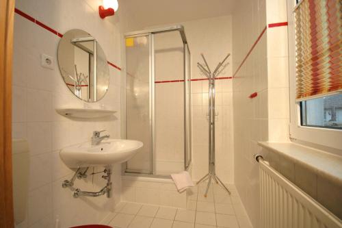 a white bathroom with a sink and a shower at Pension Schwalbenhof in Klausdorf Mecklenburg Vorpommern