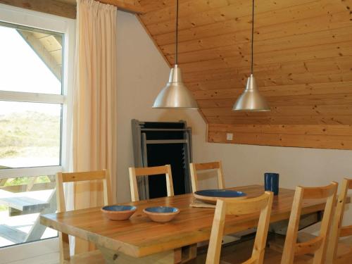 a dining room with a wooden table with bowls on it at 6 person holiday home in Ringk bing in Klegod