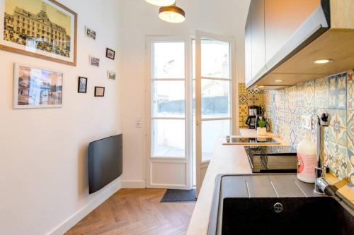 une cuisine avec un évier et une cuisinière four supérieur dans l'établissement Appartement de charme centre ville avec terasse, à Saint-Brieuc