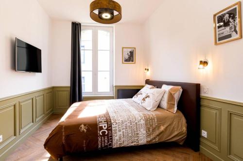 - une chambre avec un lit, une télévision et une fenêtre dans l'établissement Appartement de charme centre ville avec terasse, à Saint-Brieuc