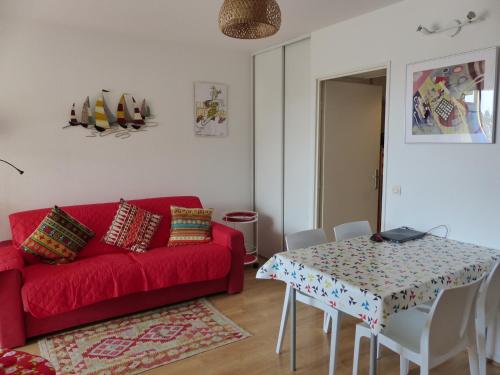 un salon avec un canapé rouge et une table dans l'établissement Appartement Pour 4 Personnes Avec Vue Sur Le Port De Plaisance- Residence Le Genois, à Capbreton