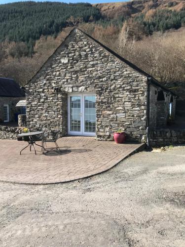 a stone building with a picnic table in front of it at Culag Lochside Self Catering in Luss