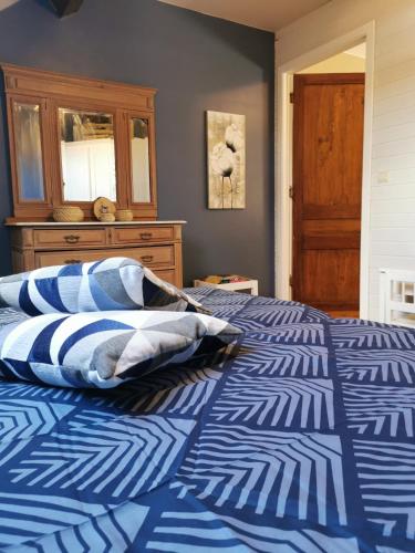 ein Bett mit einer blauen und weißen Bettdecke in einem Schlafzimmer in der Unterkunft Cépage de la Tourelle in Ways