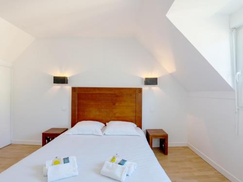 een slaapkamer met een wit bed met 2 kussens bij Vacancéole - Résidence Les Terrasses de Pentrez-Plage in Pentrez