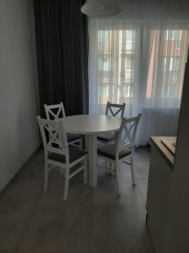 a white dining table and chairs in a kitchen at Vasco in Racibórz