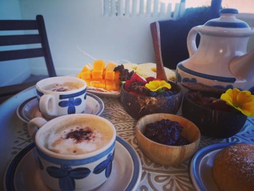 einen Tisch mit Tassen Kaffee und Schüsseln mit Essen in der Unterkunft B&b Villa Rosalia in Procida