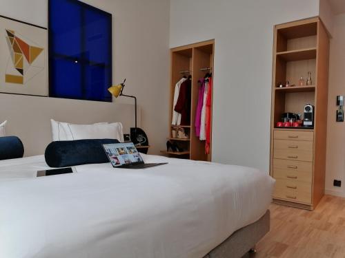 a bedroom with a large white bed and a closet at Le Grand Quartier in Paris