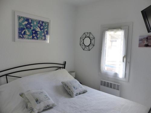 A bed or beds in a room at Appartement Pour 4 Personnes Avec Vue Sur Le Port De Plaisance- Residence Le Genois