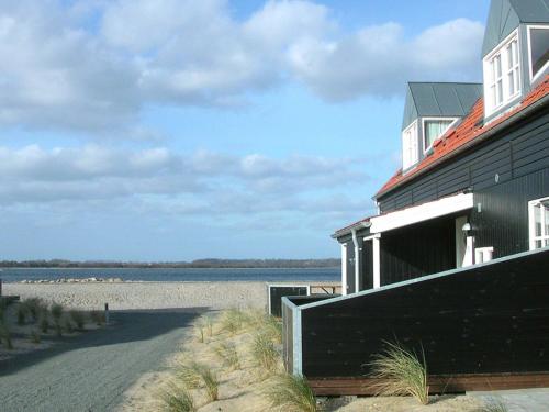 uma casa na praia ao lado de um corpo de água em 6 person holiday home in Juelsminde em Juelsminde