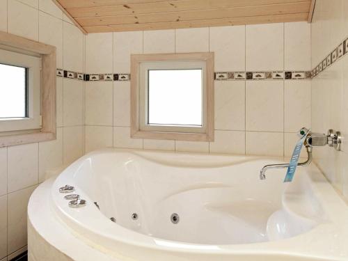 a white tub in a bathroom with two windows at 6 person holiday home in Henne in Henne Strand