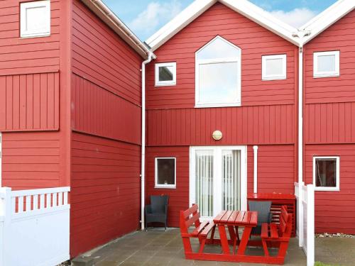 Øster Hurupにある6 person holiday home in Hadsundの赤い椅子とテーブルのある赤い建物