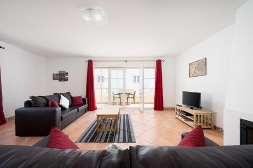 a living room with a couch and a tv at Traditional Seaside Tavira Apartment in Cabanas de Tavira