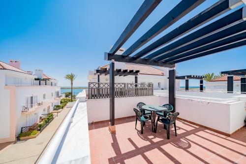 a patio with a table and chairs on a balcony at Traditional Seaside Tavira Apartment in Cabanas de Tavira