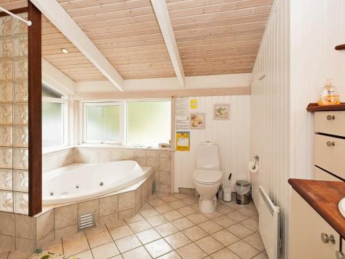 a bathroom with a tub and a toilet at 8 person holiday home in Ebeltoft-By Traum in Ebeltoft