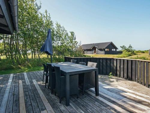 a table and chairs on a deck with an umbrella at 8 person holiday home in Ebeltoft-By Traum in Ebeltoft