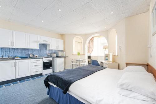 a bedroom with a large bed and a kitchen at Sandpiper Holiday Apartments in Blackpool