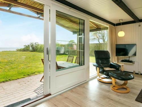 un porche cubierto con silla y TV en 6 person holiday home in Bjert, en Binderup Strand