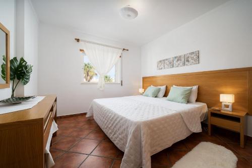 um quarto com uma cama branca e uma janela em Family Holiday Apartment - Centrally Located - Vale de Parra em Albufeira