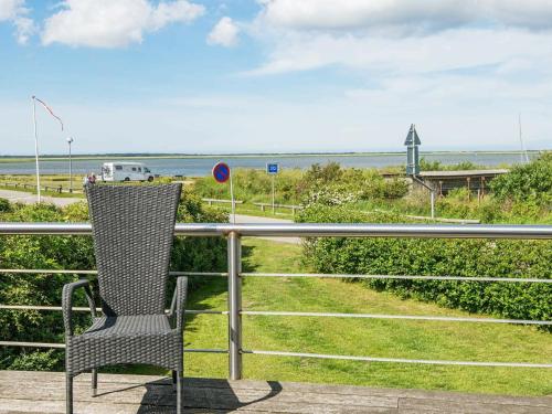 a chair sitting on a balcony looking out at the ocean at 6 person holiday home in Hemmet in Falen