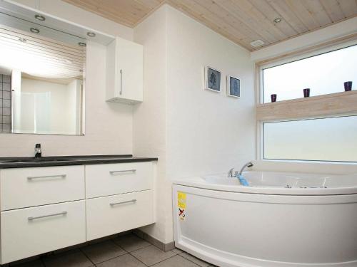 ÅlbækにあるFour-Bedroom Holiday home in Ålbæk 7のバスルーム(バスタブ、シンク付)、窓が備わります。