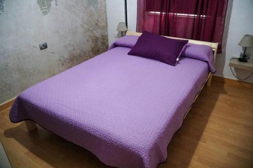 a bed with a purple comforter in a room at Casa Toribio in El Río