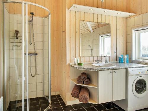 a bathroom with a sink and a shower and a washing machine at 6 person holiday home in Storvorde-By Traum in Egense