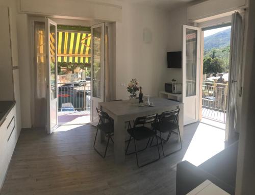 een keuken met een tafel en stoelen en een balkon bij HOST IN LEVANTO - Maestrale con biciclette in Levanto