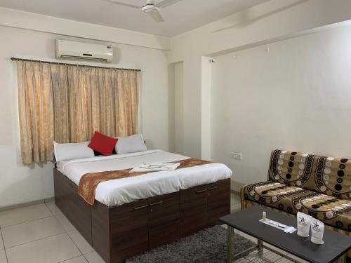 ein Schlafzimmer mit einem Bett und einem Sofa in einem Zimmer in der Unterkunft JK Rooms 147 Lions - Koradi Nagpur in Nagpur