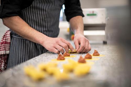 a man is preparing food in a kitchen at Hotel Plan Murin in La Valle