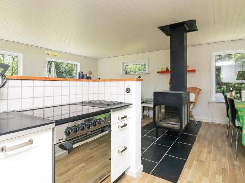 uma cozinha com um fogão e um fogão forno superior em 6 person holiday home in S by em Nordost