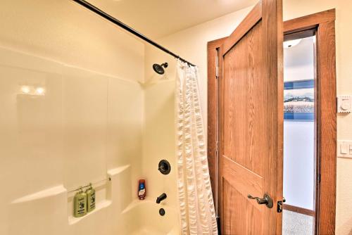 La salle de bains est pourvue d'une douche et d'une porte en bois. dans l'établissement Gorgeous Twin Lakes Home with Deck Overlooking Mtns!, à Twin Lakes