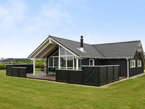 a house with a black roof and a deck at 6 person holiday home in Tarm in Hemmet