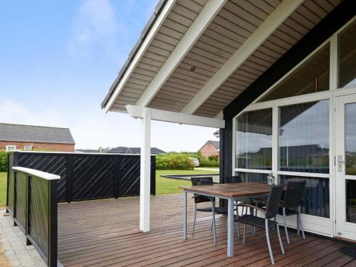 a patio with a table and chairs on a deck at 6 person holiday home in Tarm in Hemmet