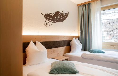 two beds in a hotel room with a fish on the wall at Hotel Hemizeus & Iremia Spa in Zermatt