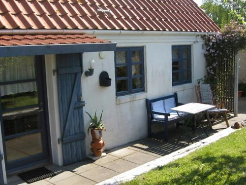 a small house with a bench and a table at 4 person holiday home in Bramming in Bramming