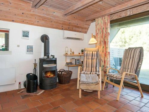 a living room with a wood stove and a chair at 8 person holiday home in Glesborg in Fjellerup