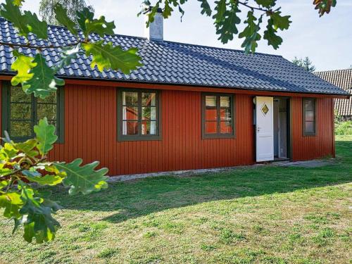 a red house with a black roof at 6 person holiday home in Nex in Snogebæk