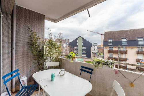 Il dispose d'un balcon avec une table et des chaises blanches. dans l'établissement ROSA, Confortable 2 chambres avec parking dans le centre, à Rennes