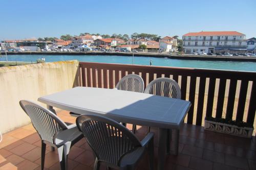 a table and chairs on a balcony with a view of the water at Appartement Pour 3/4 Personnes Avec Vue Sur Le Port De Plaisance- Residence Notre-Dame in Capbreton