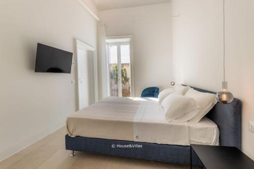 a white bedroom with a bed with white pillows at Casa Ruiz Suites in Noto