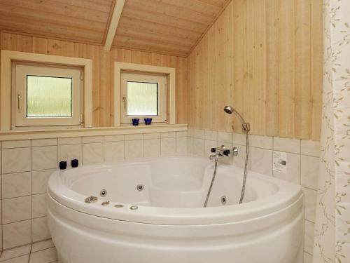 - Baño con bañera blanca y 2 ventanas en 6 person holiday home in Ansager, en Ansager