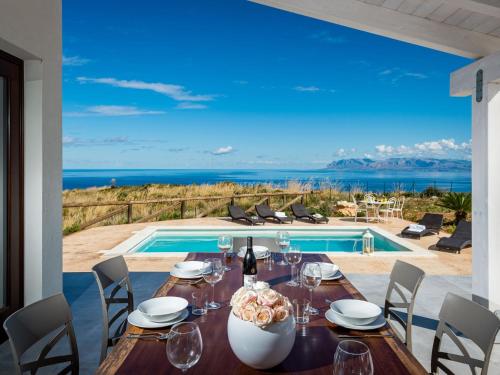 una sala da pranzo con tavolo e piscina di Villa Rocchi Livreri by Interhome a Scopello